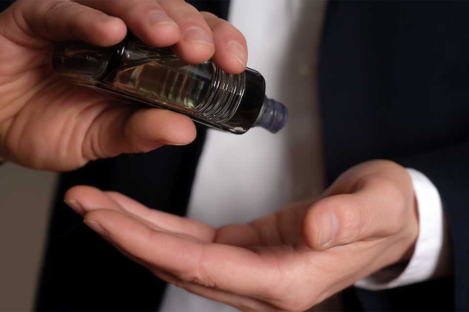 A man pouring aftershave into his hand.