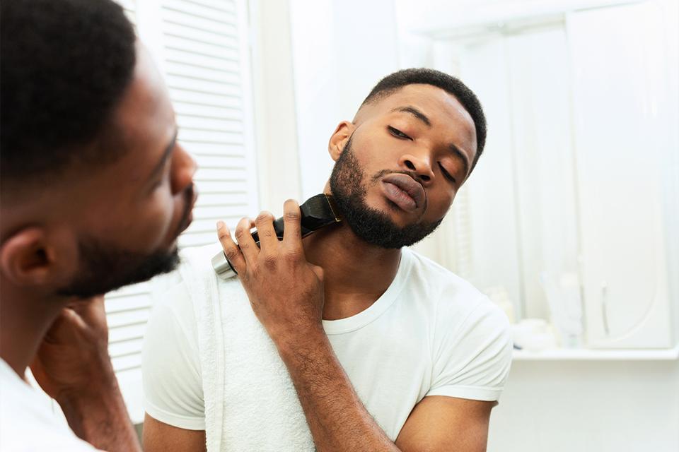 Man shaving his beard in the mirror.
