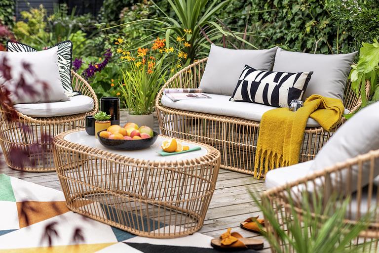 An Argos Home Lexy 4-seater rattan garden sofa set in a garden.