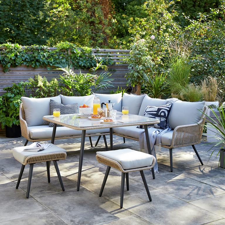 A Habitat 6 seater steel corner dining set in grey placed on a garden deck. 