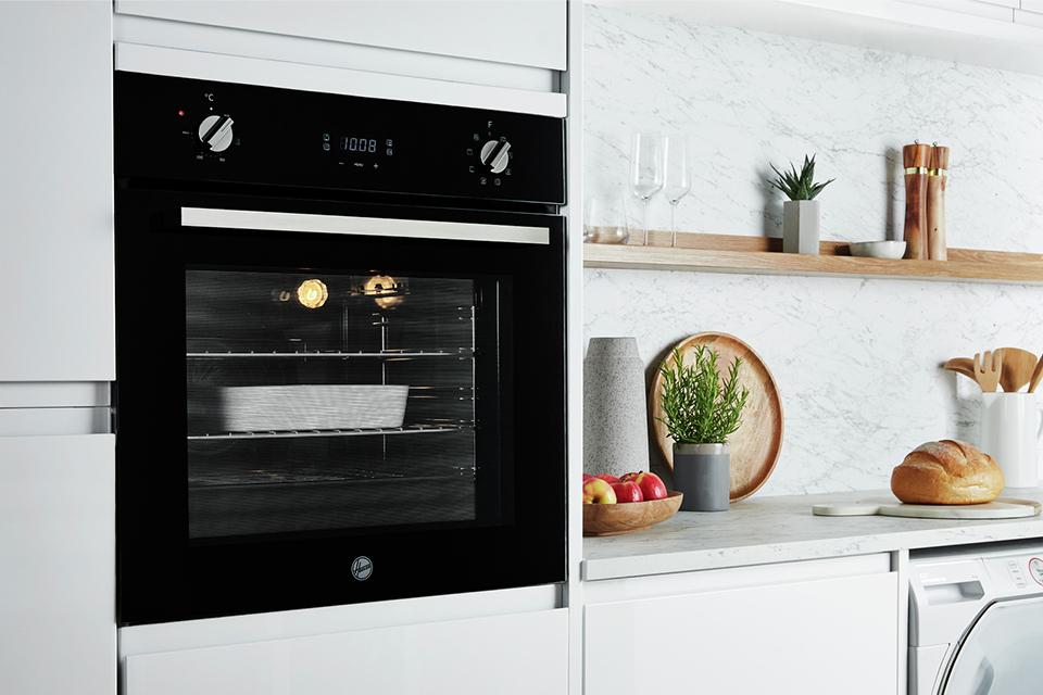 A black built-in Hoover single oven in a white kitchen.