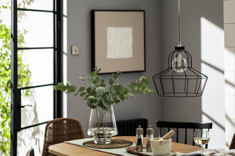 Black metal lamp shade hanging above dining room set.