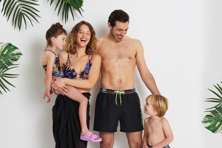 A family of four in swimming wear.