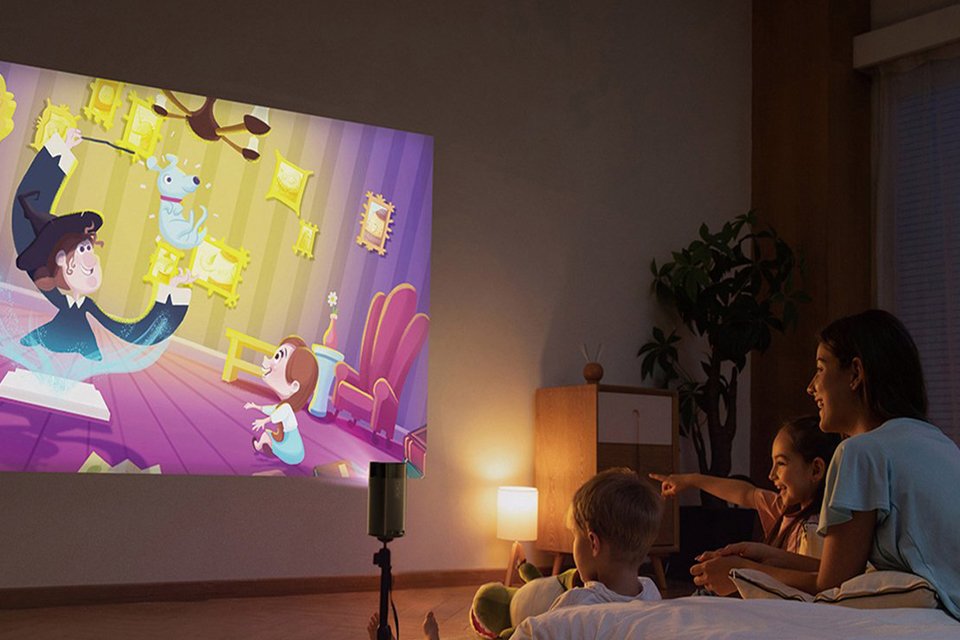 A mother watching an animated movie with her kids in a bedroom using a Nebula Apollo smart portable projector.