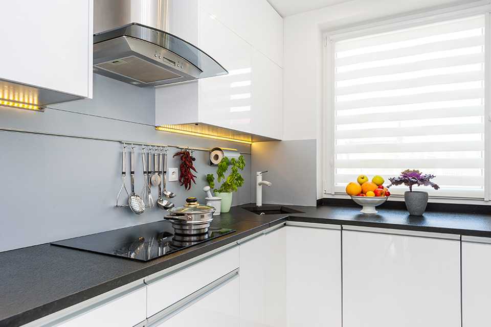 A modern kitchen with a white venetian blind.