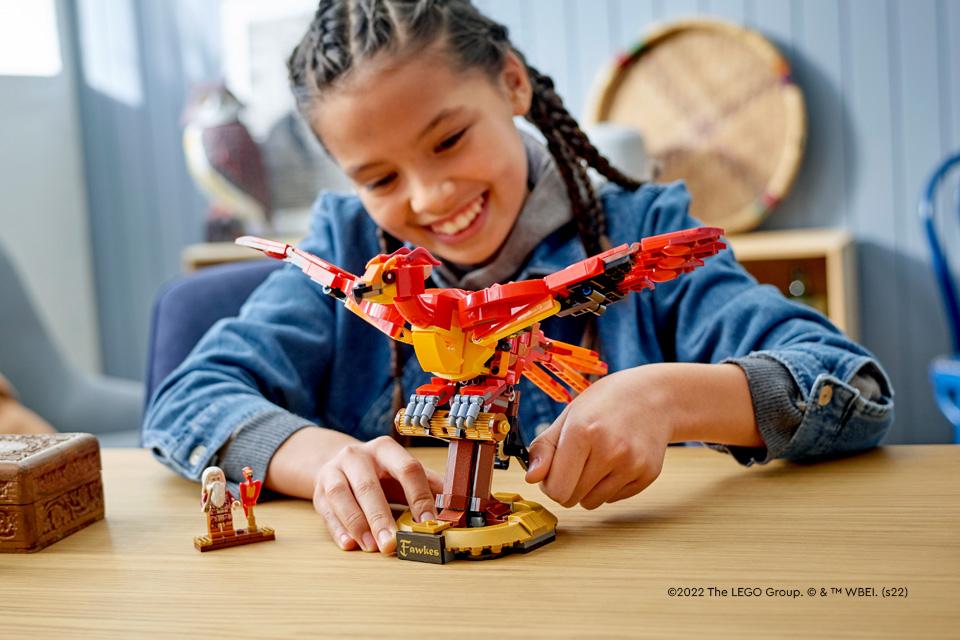 A girl plays with the LEGO® Harry Potter Phoenix.