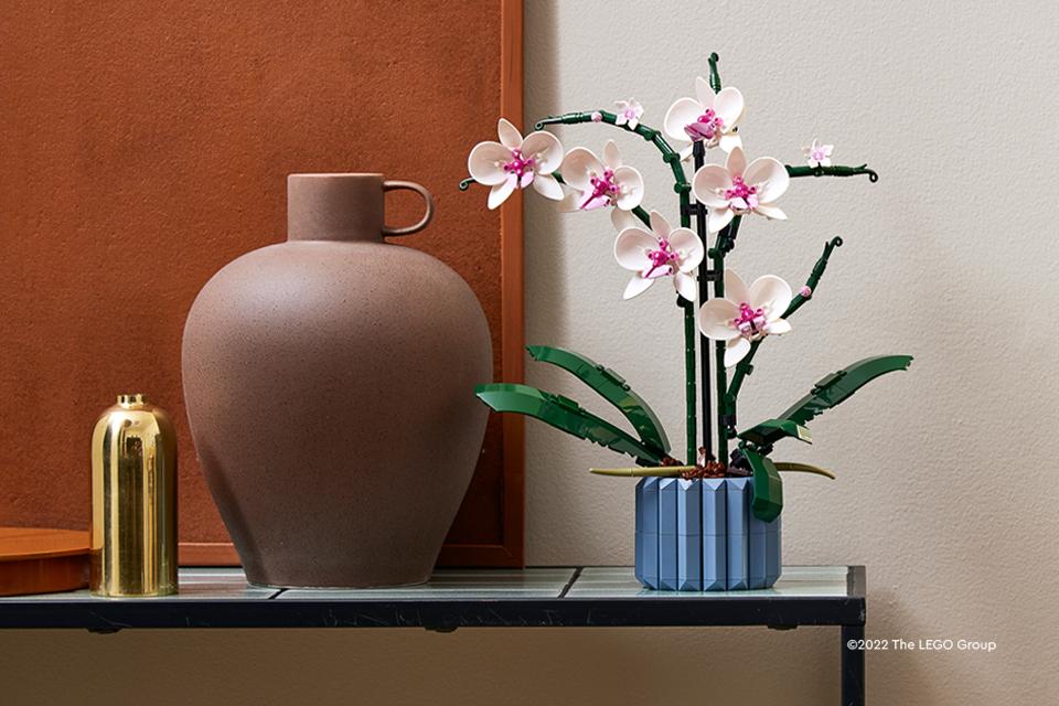 A pink and white LEGO® orchid in a blue vase.