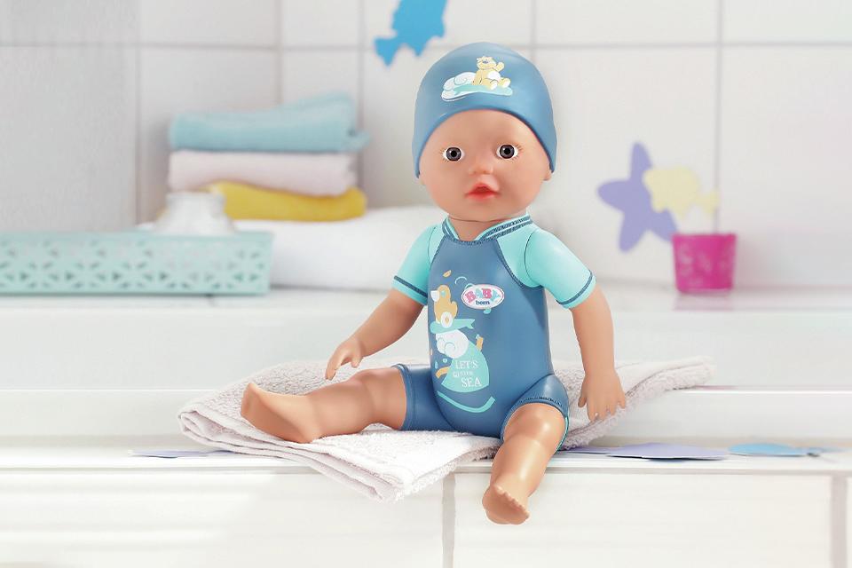 A BABY born My First swim doll in a blue swimsuit.