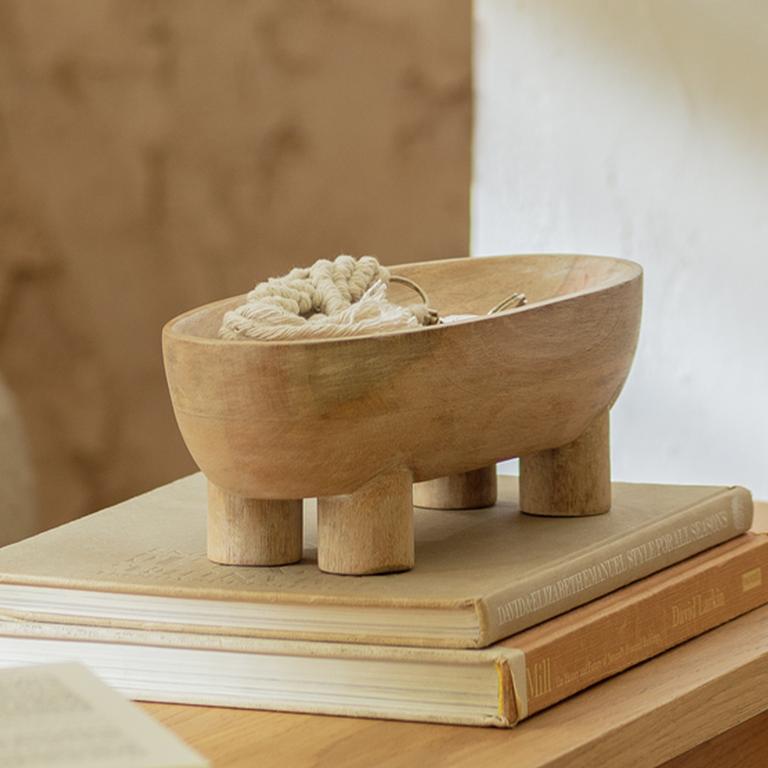 A Habitat wooden catchall in natural finish on a coffee table next to books. 