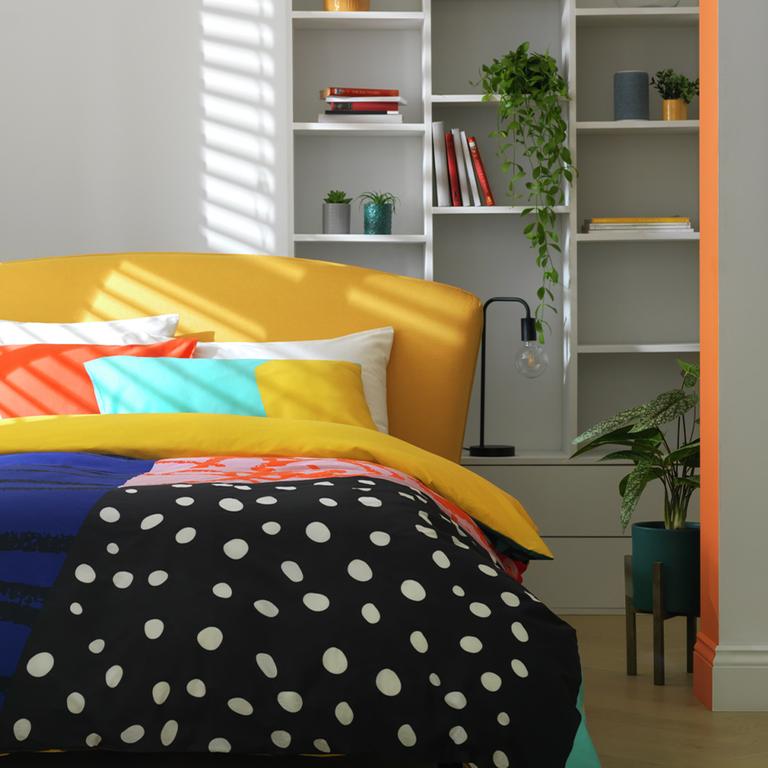 A Habitat panel print multicolour bedding set on a yellow bed. 