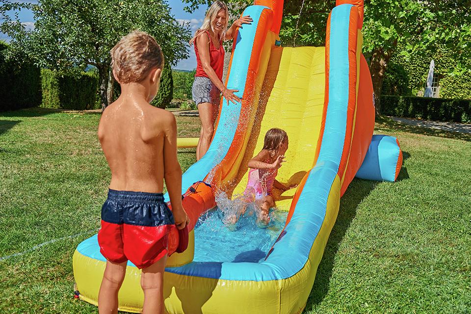 Lady and 2 children playing with the Chad Valley Inflatable Water Slide.