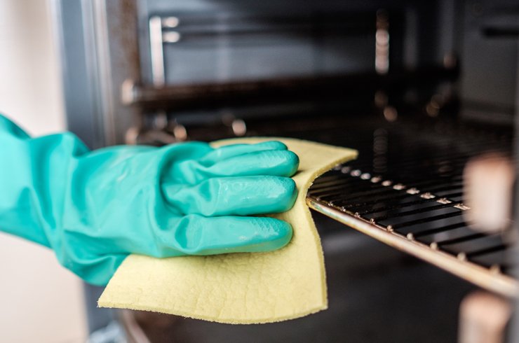 Wiping the oven grills.