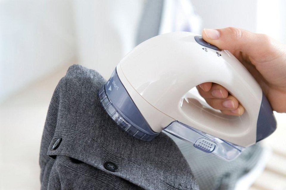 A man using a JML Bobble Off lint remover on a shirt. 