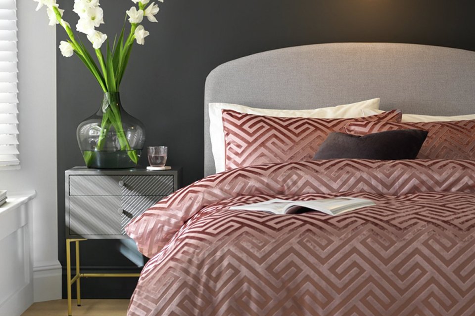 Blush pink bedding in bedroom.