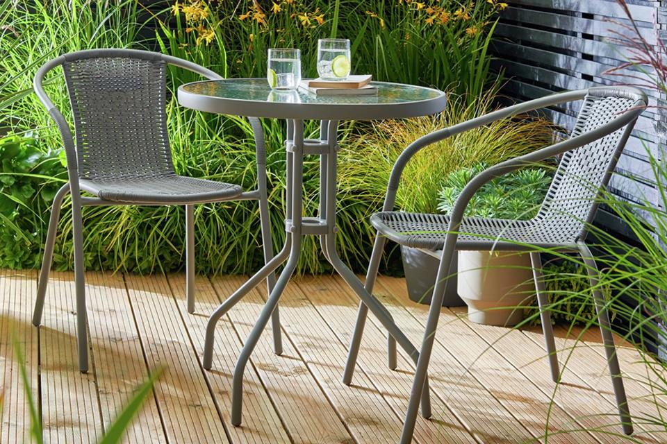 A 2 Seater rattan effect garden bistro set in grey colour placed on a deck.