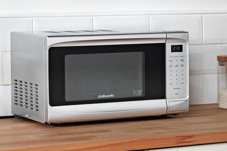 A Cookworks standard microwave on a kitchen counter.