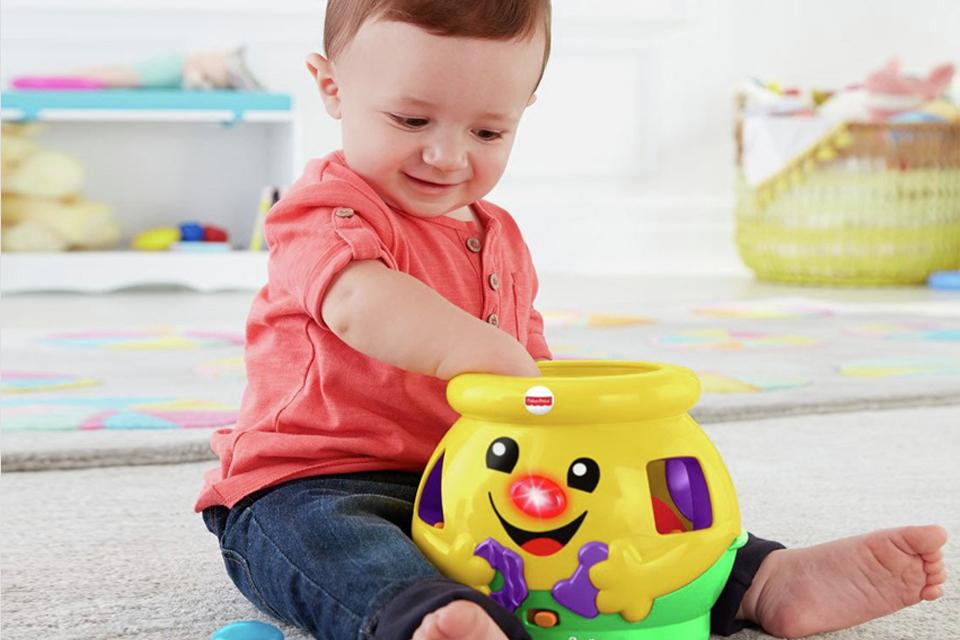 A boy playing with Fisher-Price laugh and learn cookie shape surprise.