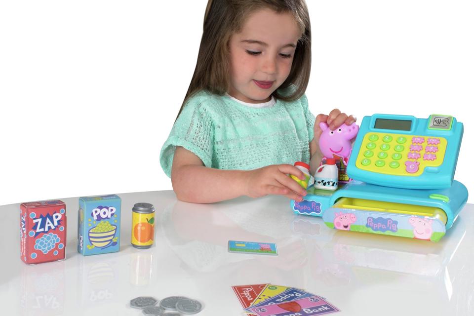 A girl playing with Peppa Pig cash register.