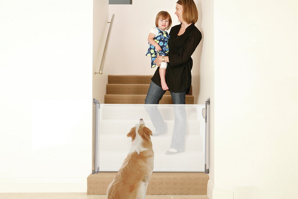 A mother carrying her baby while standing on the staircase.
