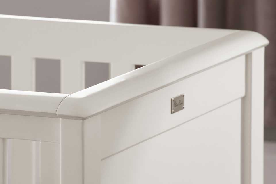 A white cot bed in a nursery.