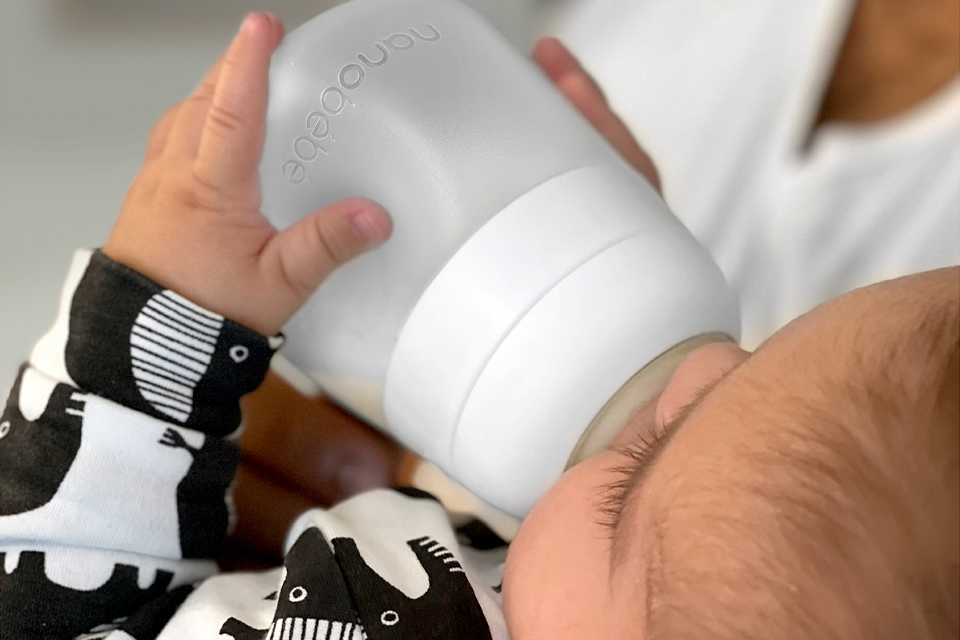 A baby drinking from Nanobebe Flexy silicone baby bottle.