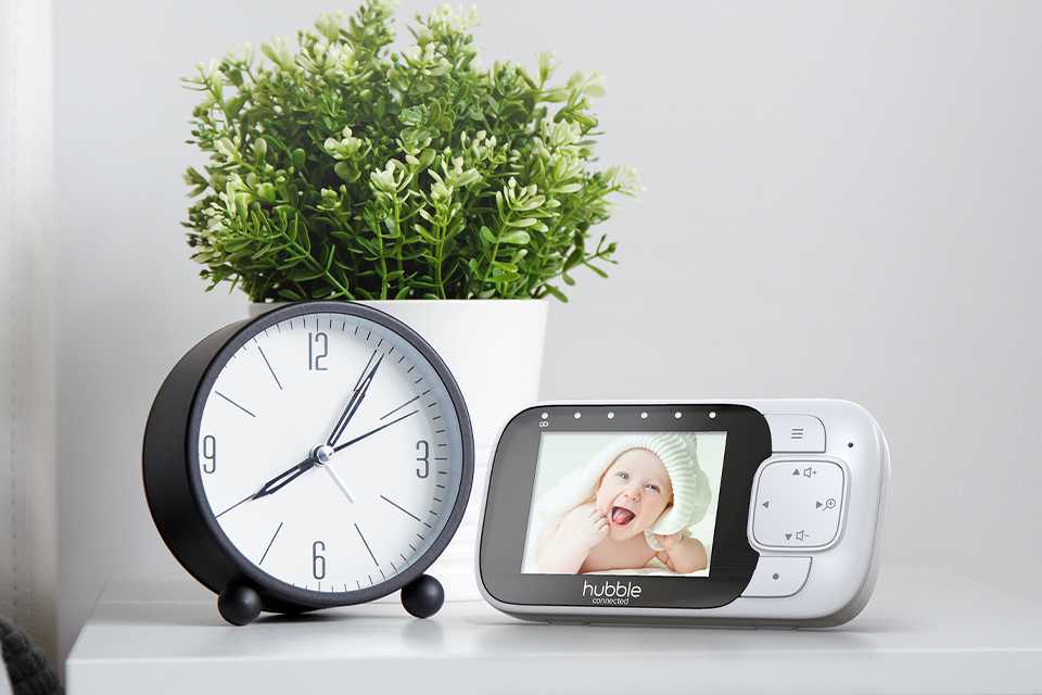 Hubble Nursery 2.8 inch view glow video baby monitor on a white bedside table.