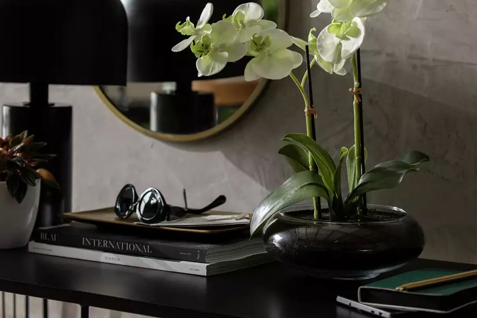 A faux floral pot on a side table.