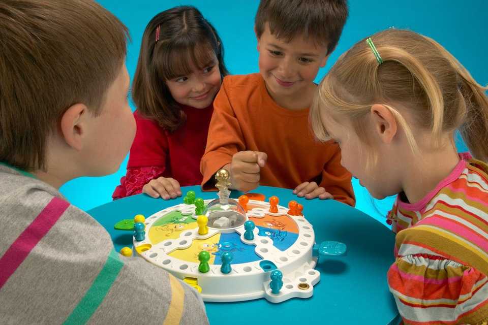 A group of kids gathered around a table to play the Frustration Game from Hasbro Gaming.