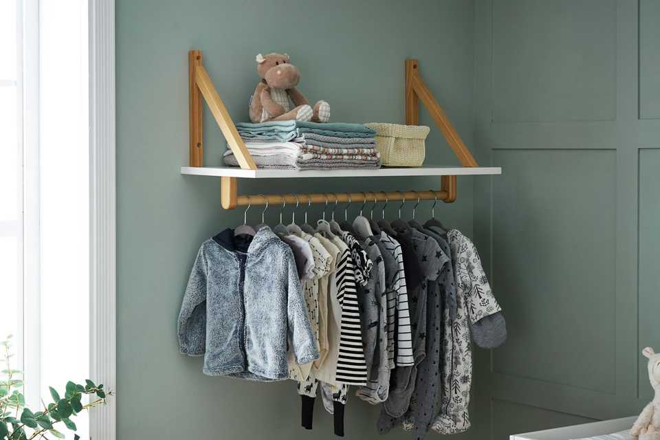 Clothes hanging on a wall shelving unit.
