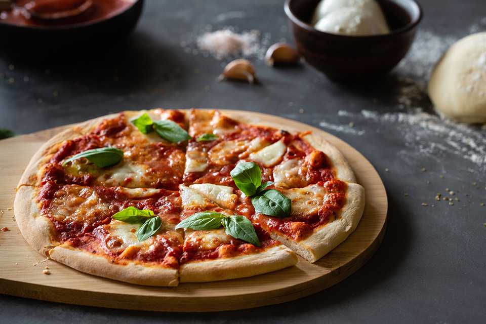 A delicious margherita pizza on a wooden board.