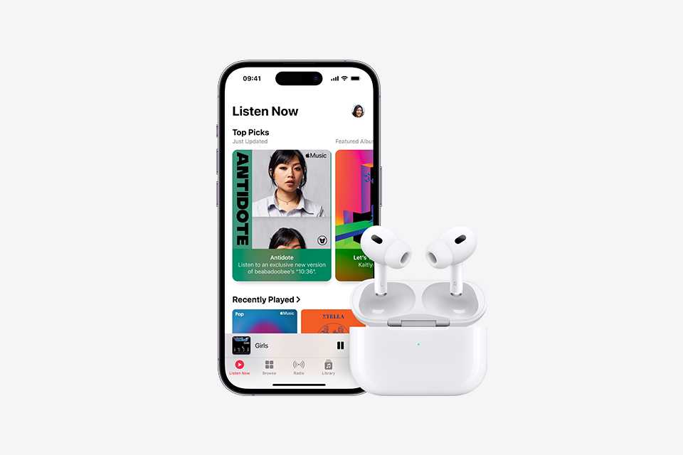 An Apple iPhone displaying Apple Music, with the Apple Music library open. Next to it is a pair of Apple AirPod Pro's with the MagSafe Charging Case.
