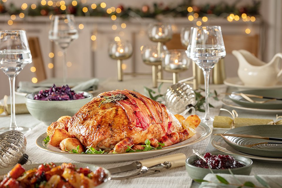 A Christmas feast set on a table including glassware, cutlery, dinner set and more.
