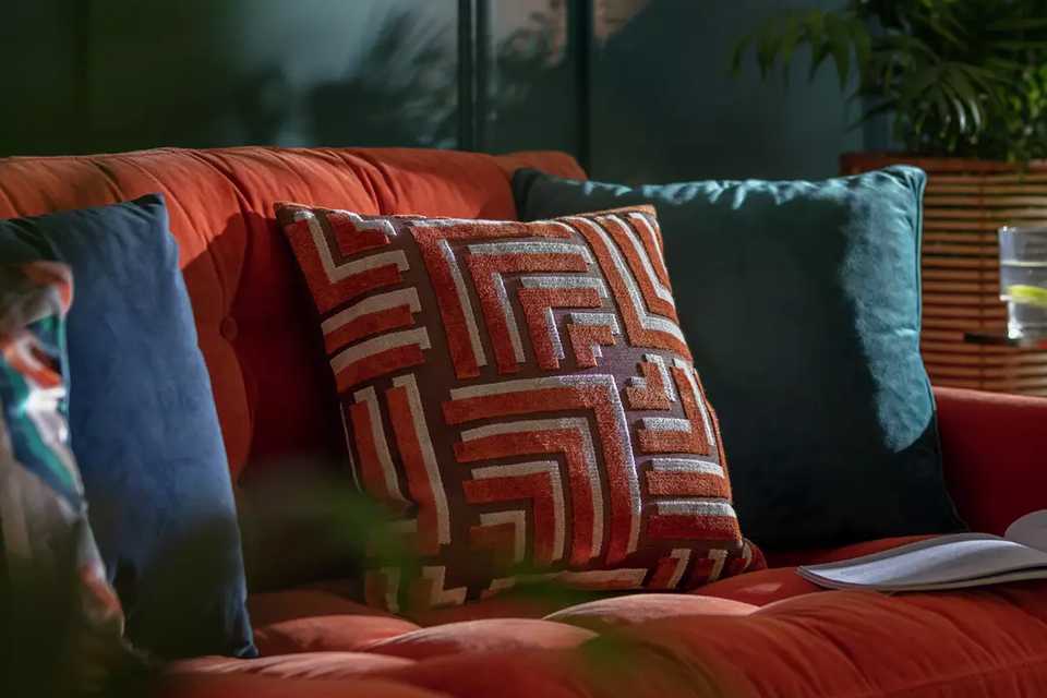 A multicolored Habitat velvet carved geo cushion. 