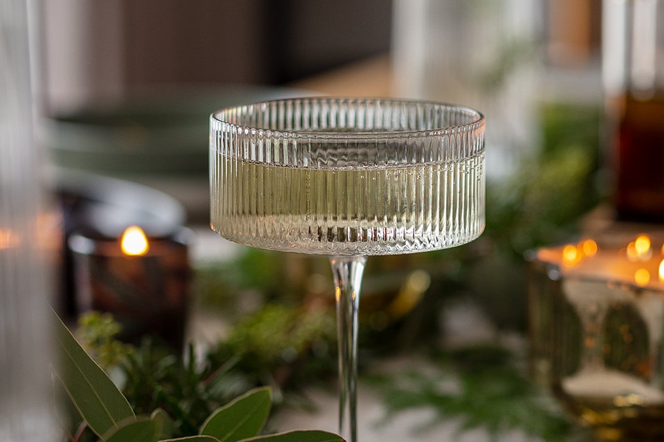 A ribbed champagne glass on a dining table. 