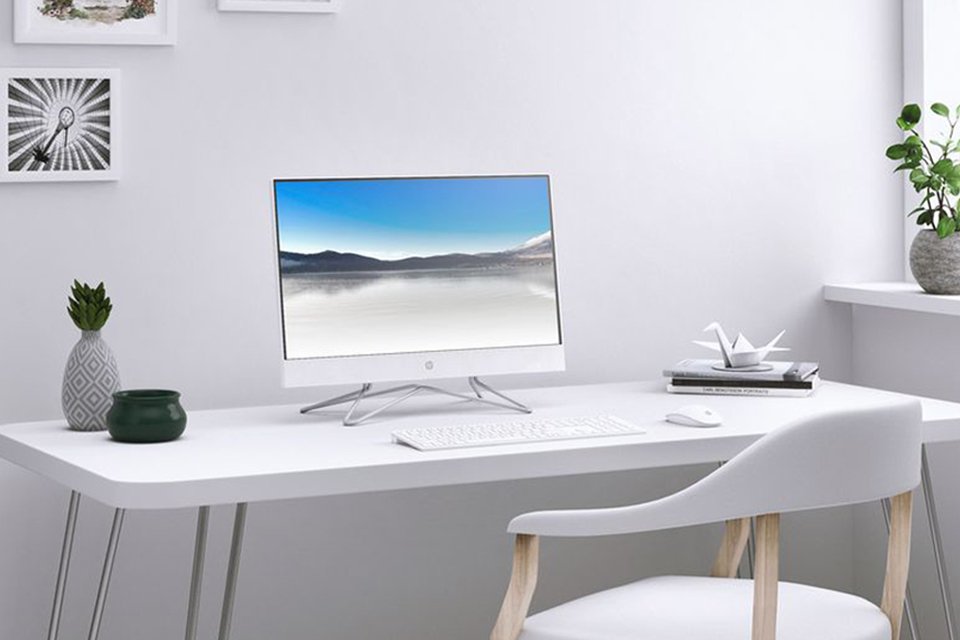 An HP monitor with a keyboard and a mouse placed on a white desk.