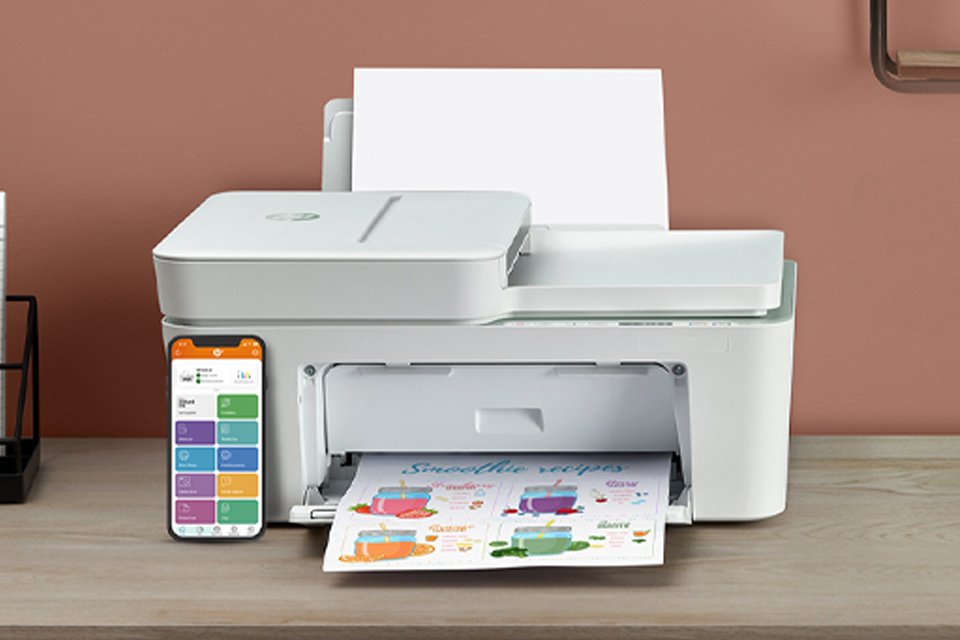 An HP printer with papers and a smartphone showing the HP Smart app interface.