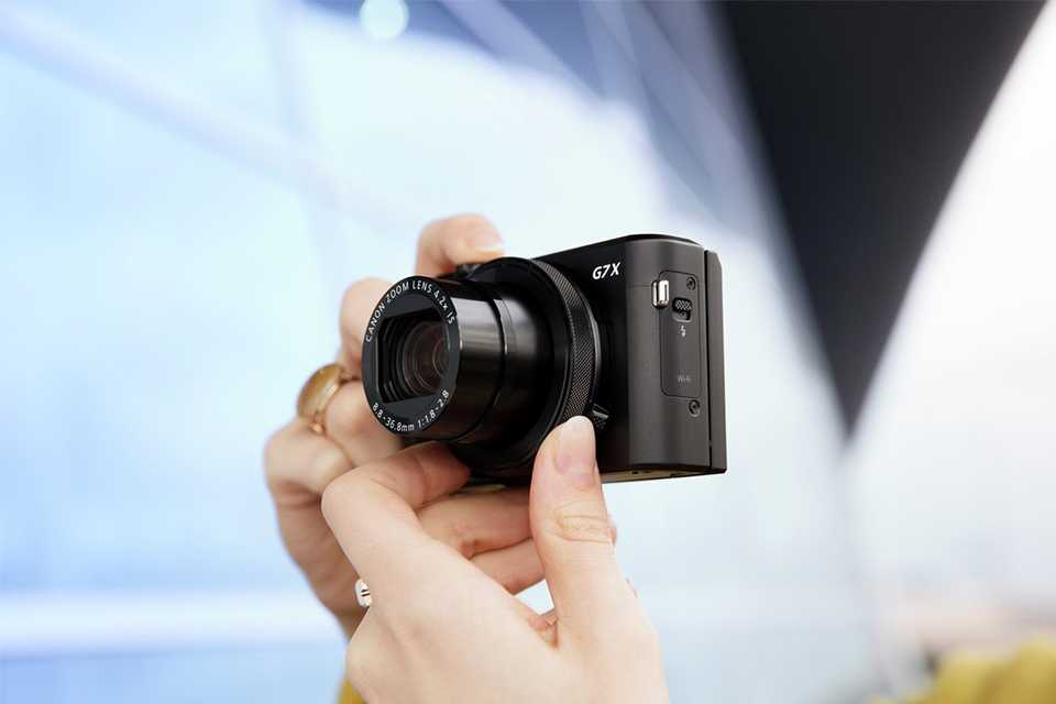  A woman clicking a picture through compact digital camera.