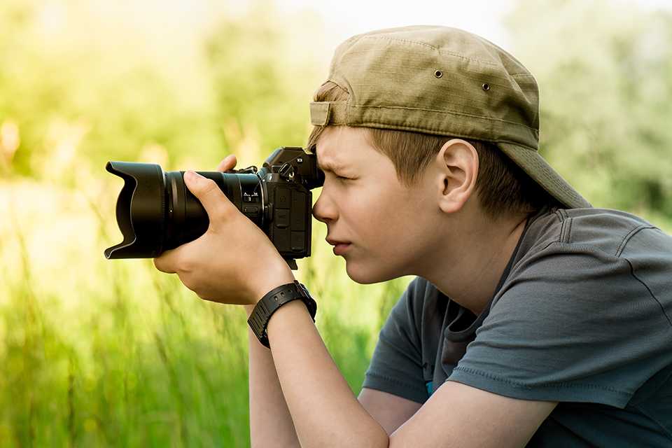  A kid clicking a picture using his DSLR.