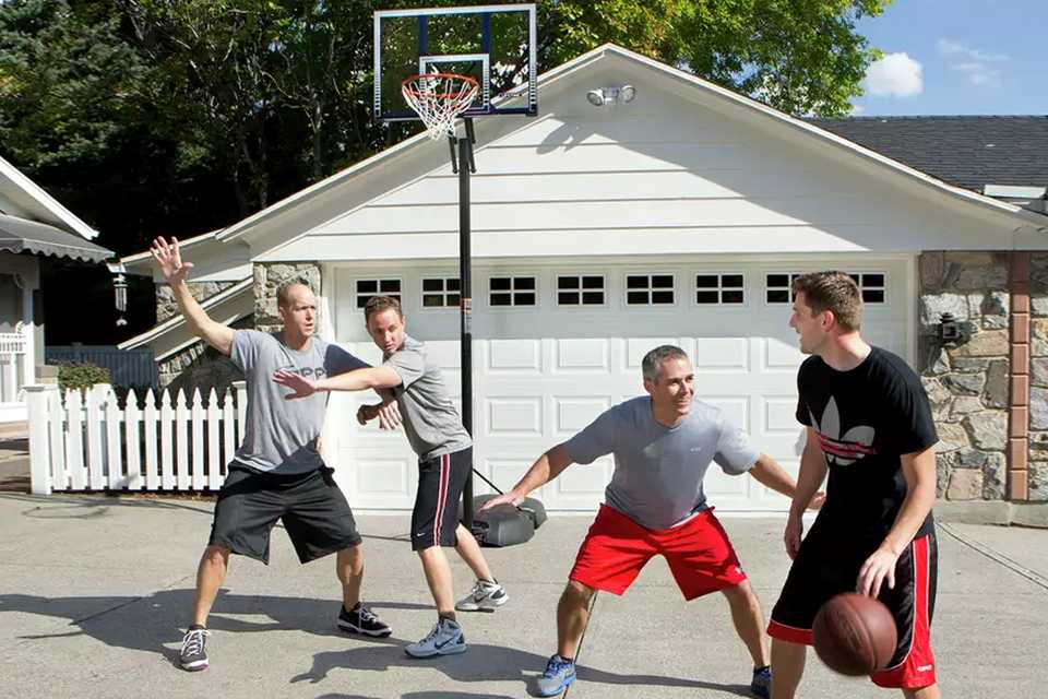 A group of men playing basketball outdoors.