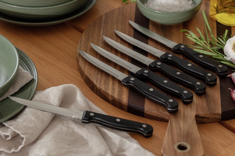 A set of Argos Home 6-piece steak knives on a cutting board.