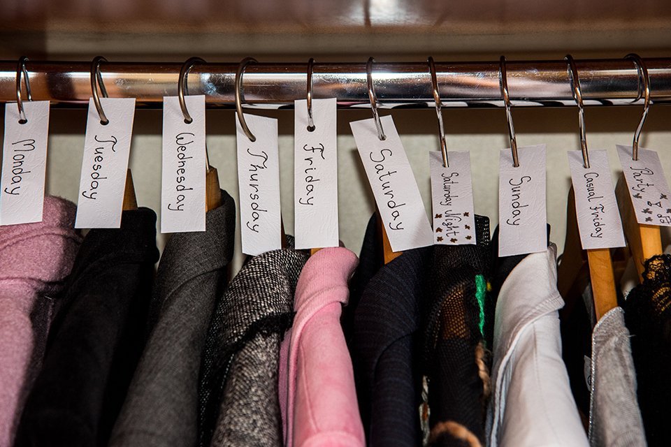 Various clothes sorted by days in a wardrobe.