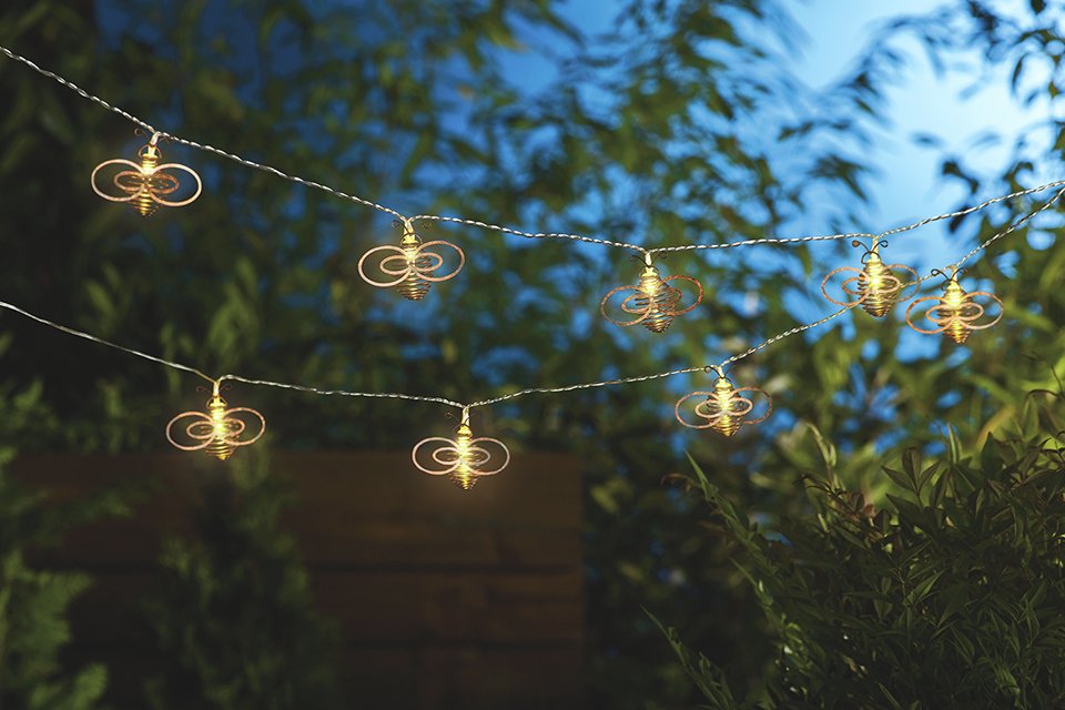 LED solar string lights hanging in a garden.