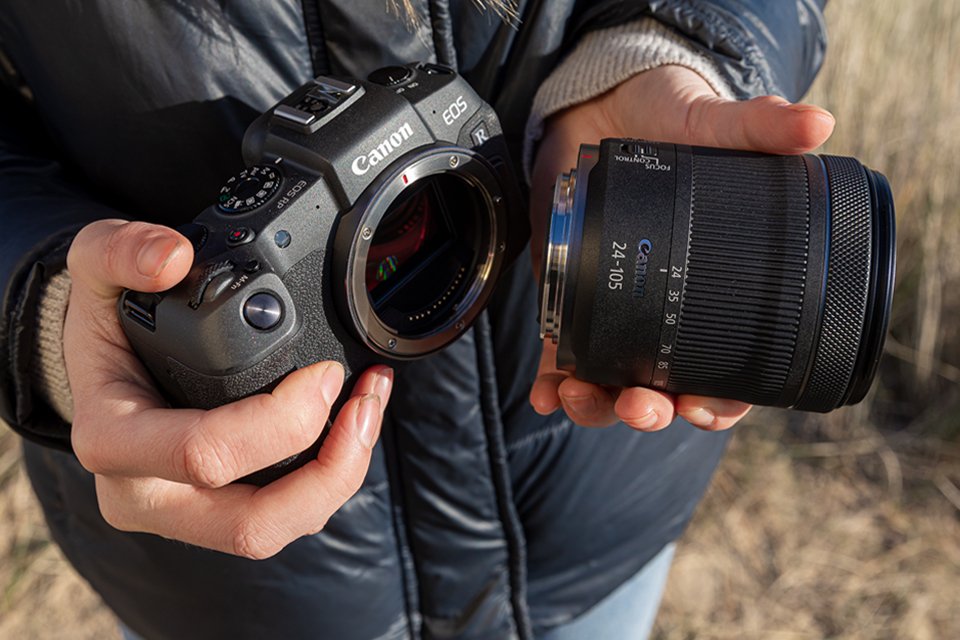 A person attaching Canon RF lenses to an interchangeable lens camera. 