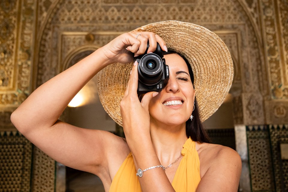 A woman clicking photograph with a Canon R-series camera. 