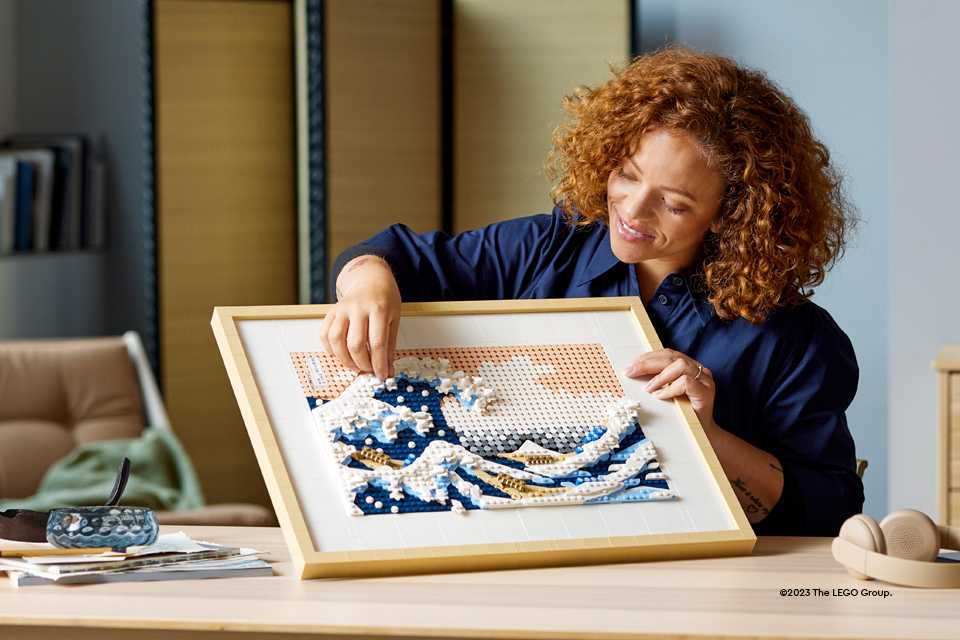 A woman builds a LEGO® replica of Hokusai's The Great Wave painting.