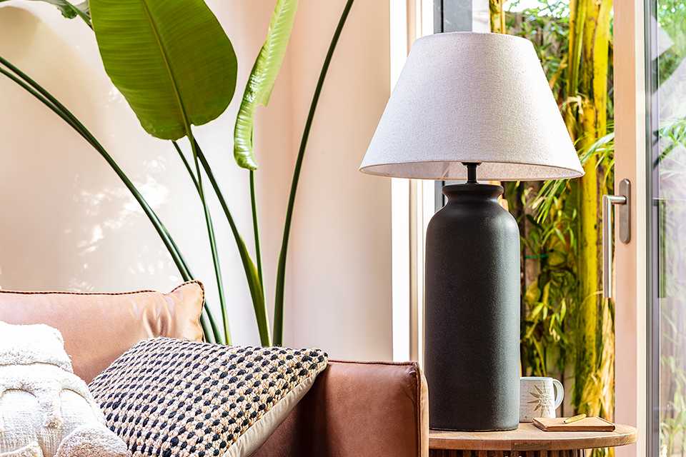 A black lamp with a white shade in a living room.