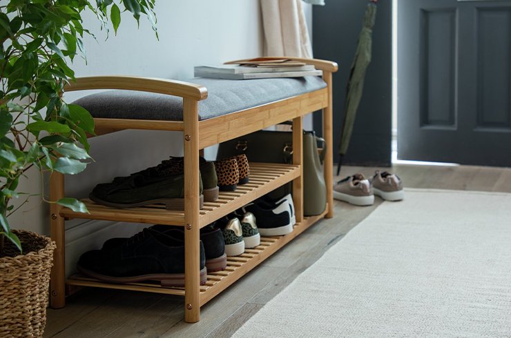 White hallway storage shelving unit next to white front door.