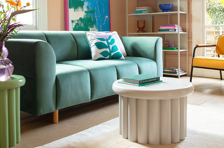 Green sofa and dusty pink armchair in living room set.