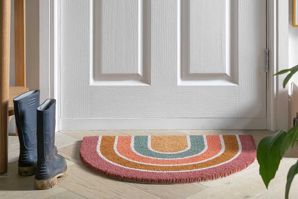 A rainbow welcome mat in a hallway.