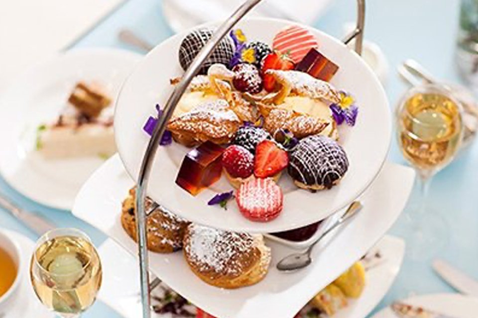 An afternoon tea table laid out with many food items and drinks.